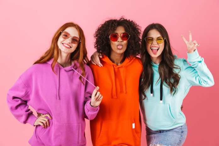 three,happy,young,girls,wearing,colorful,hoodies,standing,isolated,over